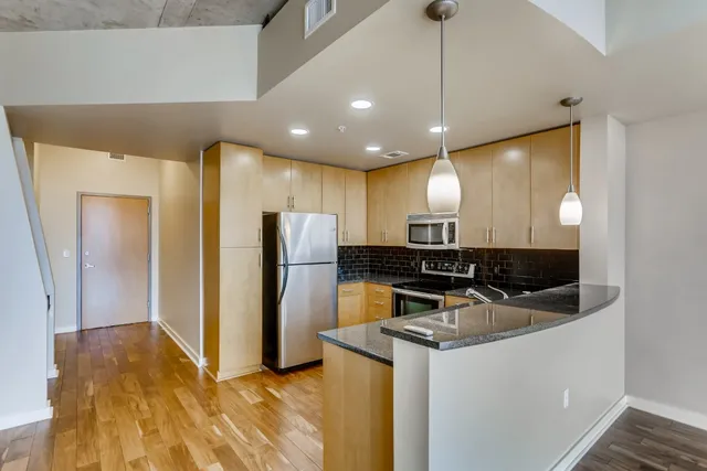 a kitchen with a sink stainless steel appliances a refrigerator and a sink