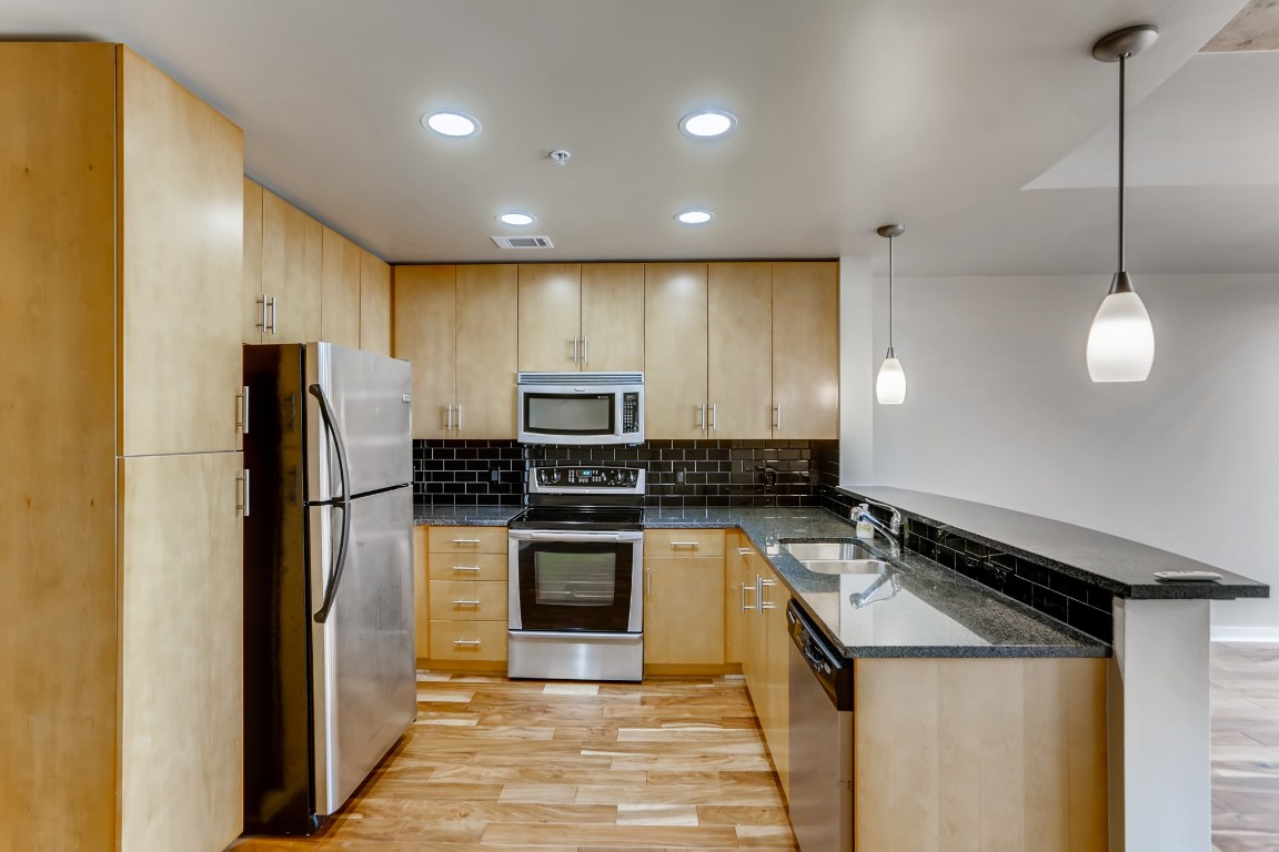 360 Nueces Street, Unit 2607 Austin, TX 78701 - Photo 9 of 23 a kitchen with a sink a counter top space stainless steel appliances and cabinets