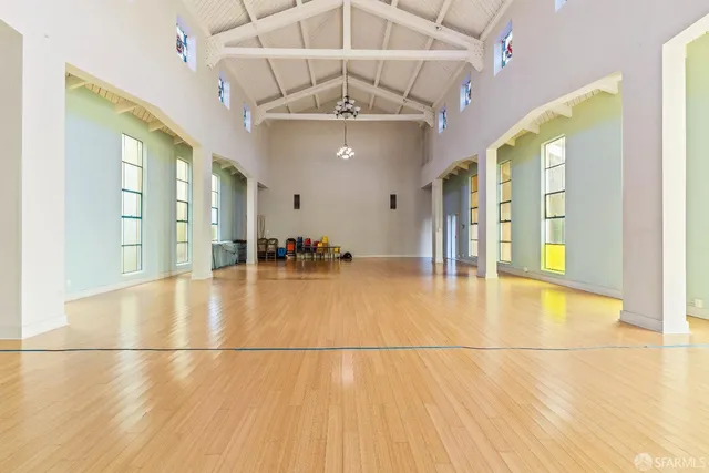 a view of a hallway with furniture and wooden floor