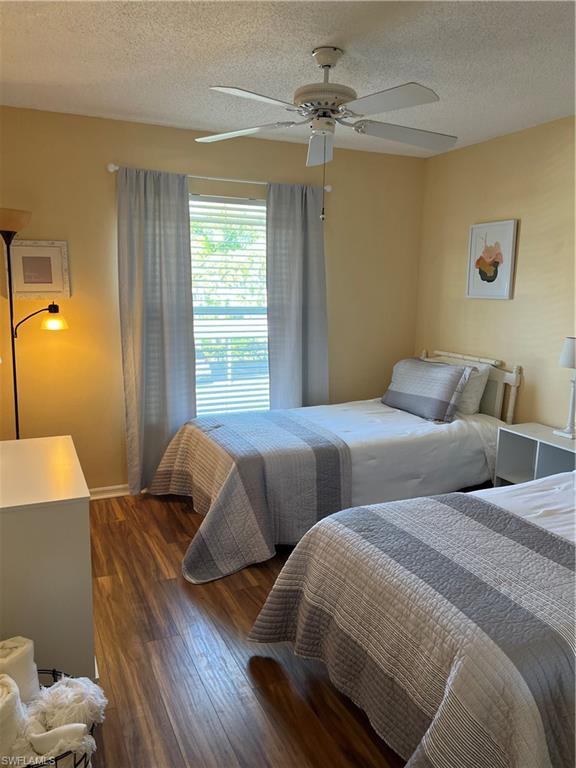 185 Grand Oaks Way, Unit R204 Naples, FL 34110 - Photo 5 of 18 a bedroom with two beds and a chandelier