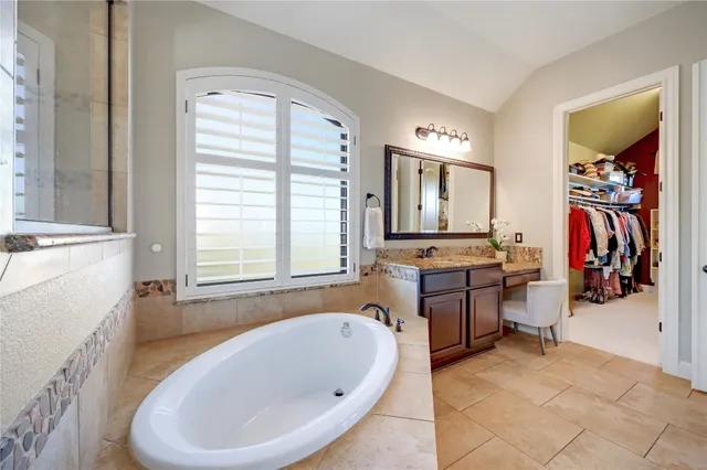 a bathroom with a tub sink and mirror