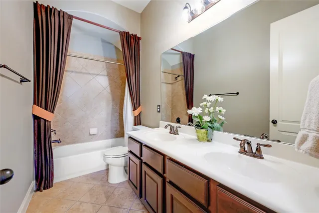 a bathroom with a double vanity sink toilet and shower