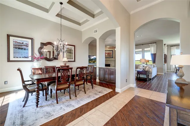 a view of a dining room and livingroom with furniture wooden floor a chandelier