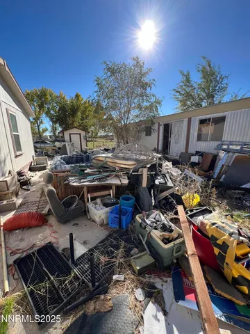 a view of a backyard with lawn chairs and a fireplace