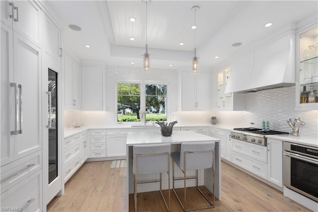 1021 6th Street South Naples, FL 34102 - Photo 14 of 44 a kitchen with a sink stove cabinets and refrigerator