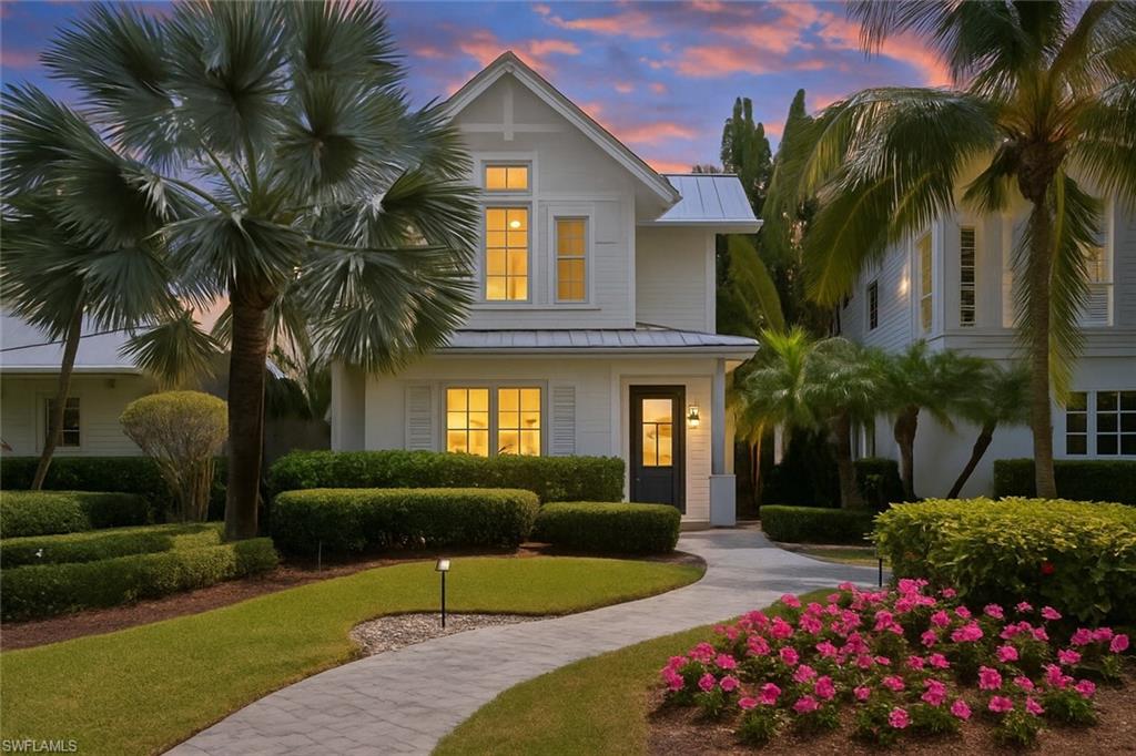 1021 6th Street South Naples, FL 34102 - Photo 2 of 44 a front view of a house with a yard and potted plants