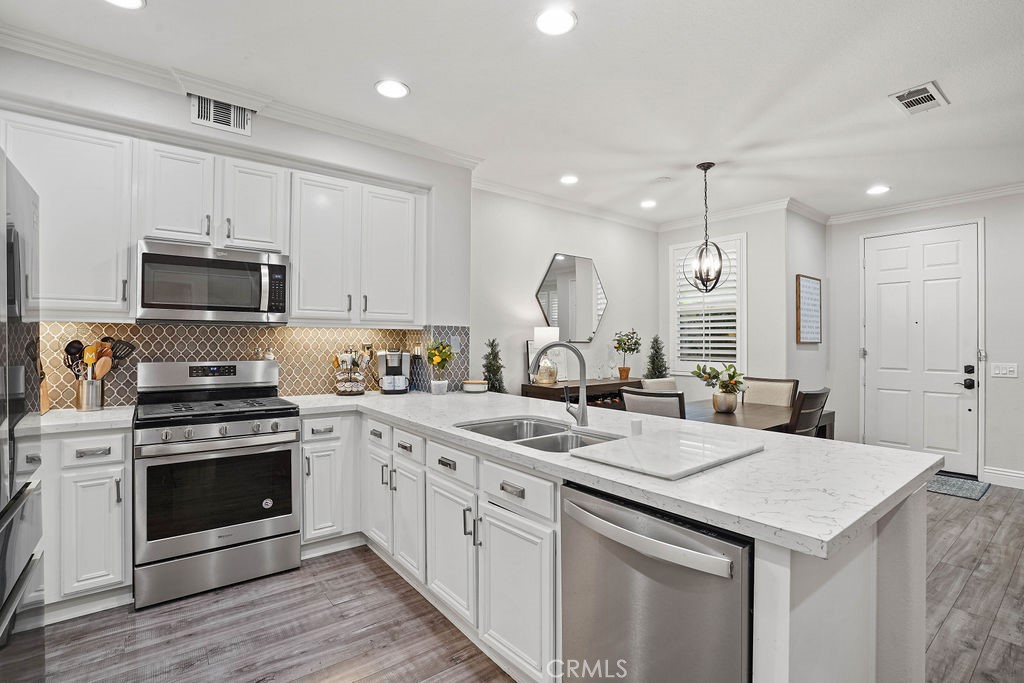 7701 Chambray Place, Unit 3 Rancho Cucamonga, CA 91739 - Photo 13 of 52 a kitchen with a sink a stove and cabinets