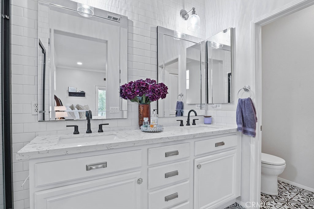 7701 Chambray Place, Unit 3 Rancho Cucamonga, CA 91739 - Photo 28 of 52 a bathroom with a granite countertop sink mirror and toilet
