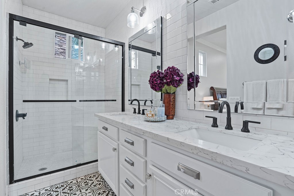 7701 Chambray Place, Unit 3 Rancho Cucamonga, CA 91739 - Photo 29 of 52 a bathroom with a granite countertop sink a shower and a mirror