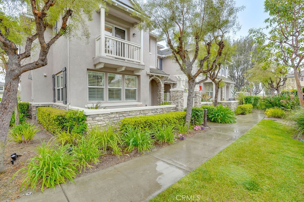 7701 Chambray Place, Unit 3 Rancho Cucamonga, CA 91739 - Photo 9 of 52 a front view of a house with a yard and potted plants