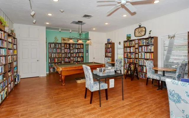 a sign board with a house in the background