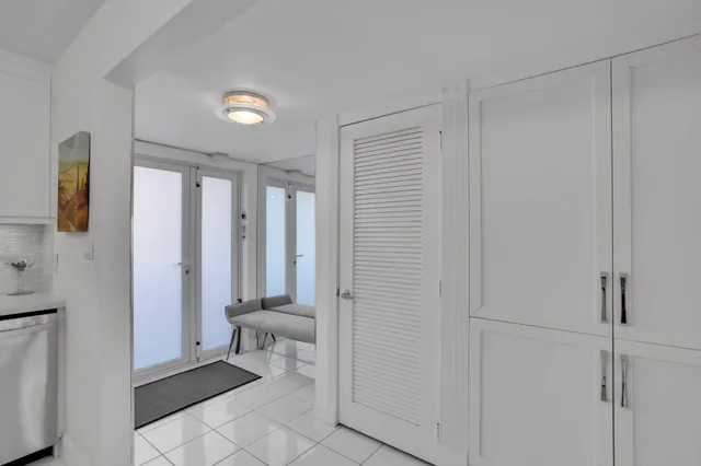 a kitchen with white cabinets and sink