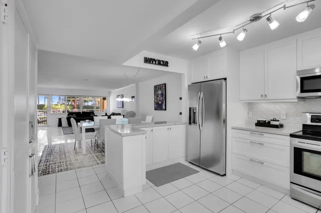 a kitchen with white cabinets stainless steel appliances and a sink