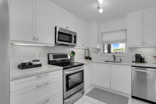 a kitchen with stainless steel appliances a refrigerator sink and cabinets