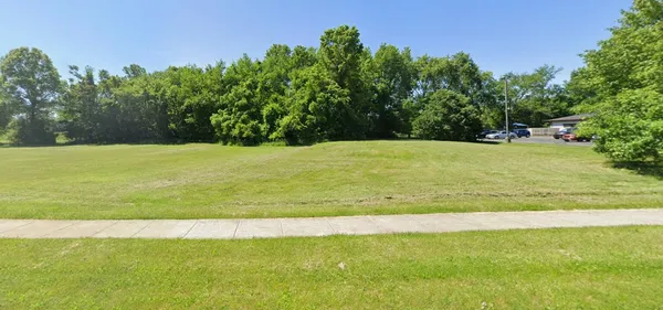a view of a field with an trees in the background