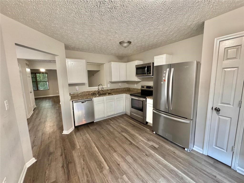 3833 Waldrop Lane Decatur, GA 30034 - Photo 11 of 20 a kitchen with a refrigerator a sink and dishwasher a oven with wooden floor