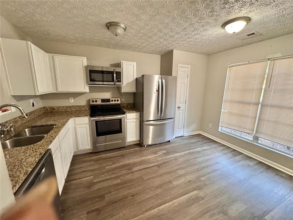 3833 Waldrop Lane Decatur, GA 30034 - Photo 4 of 20 a kitchen with granite countertop a refrigerator oven a sink and dishwasher