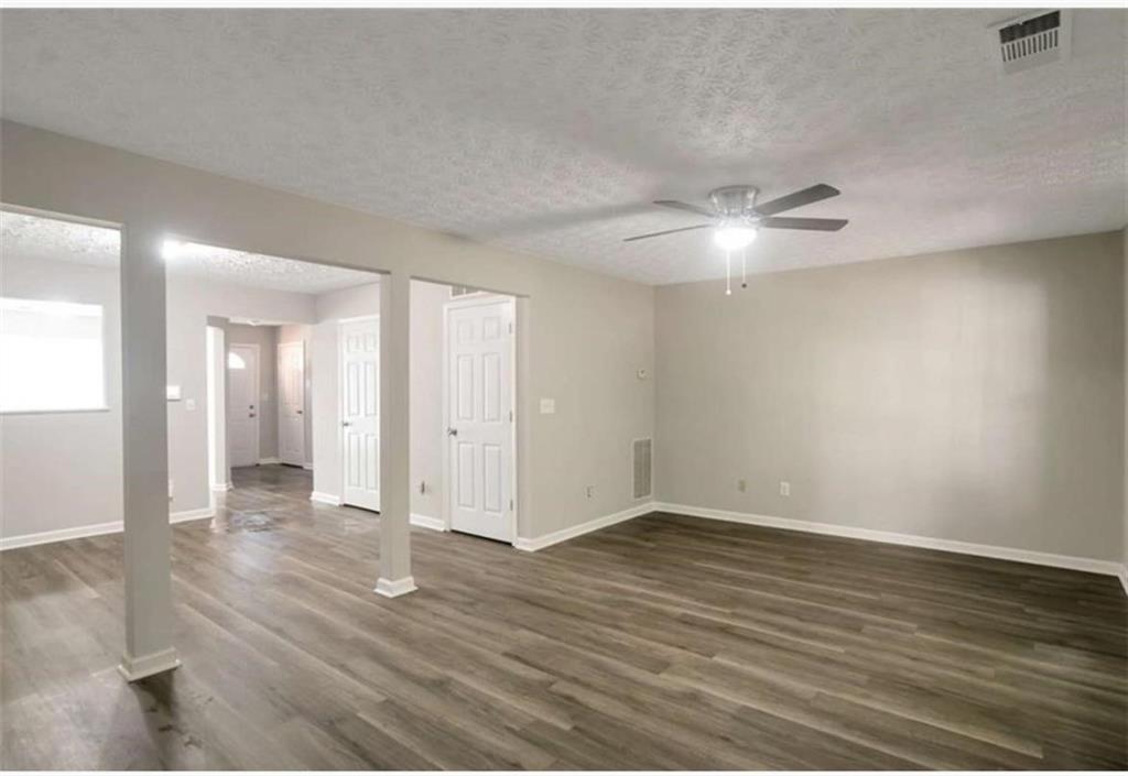 3833 Waldrop Lane Decatur, GA 30034 - Photo 7 of 20 an empty room with wooden floor and a ceiling fan
