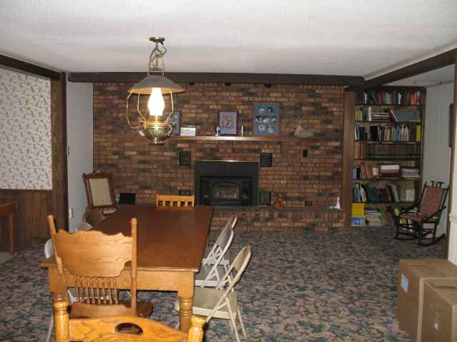 10068 Dimon Road Lanark, IL 61046 - Photo 3 of 12 a living room with fireplace furniture and a book shelf