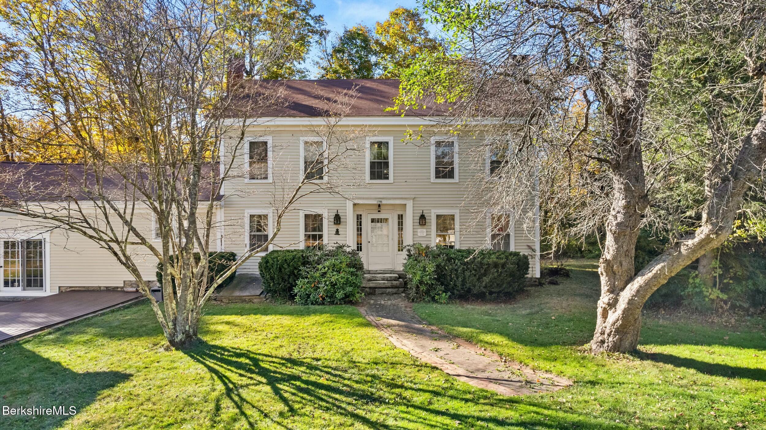 191 Sandisfield Road Sandisfield, MA 01255 - Photo 1 of 42 a view of a white house with a yard and large trees