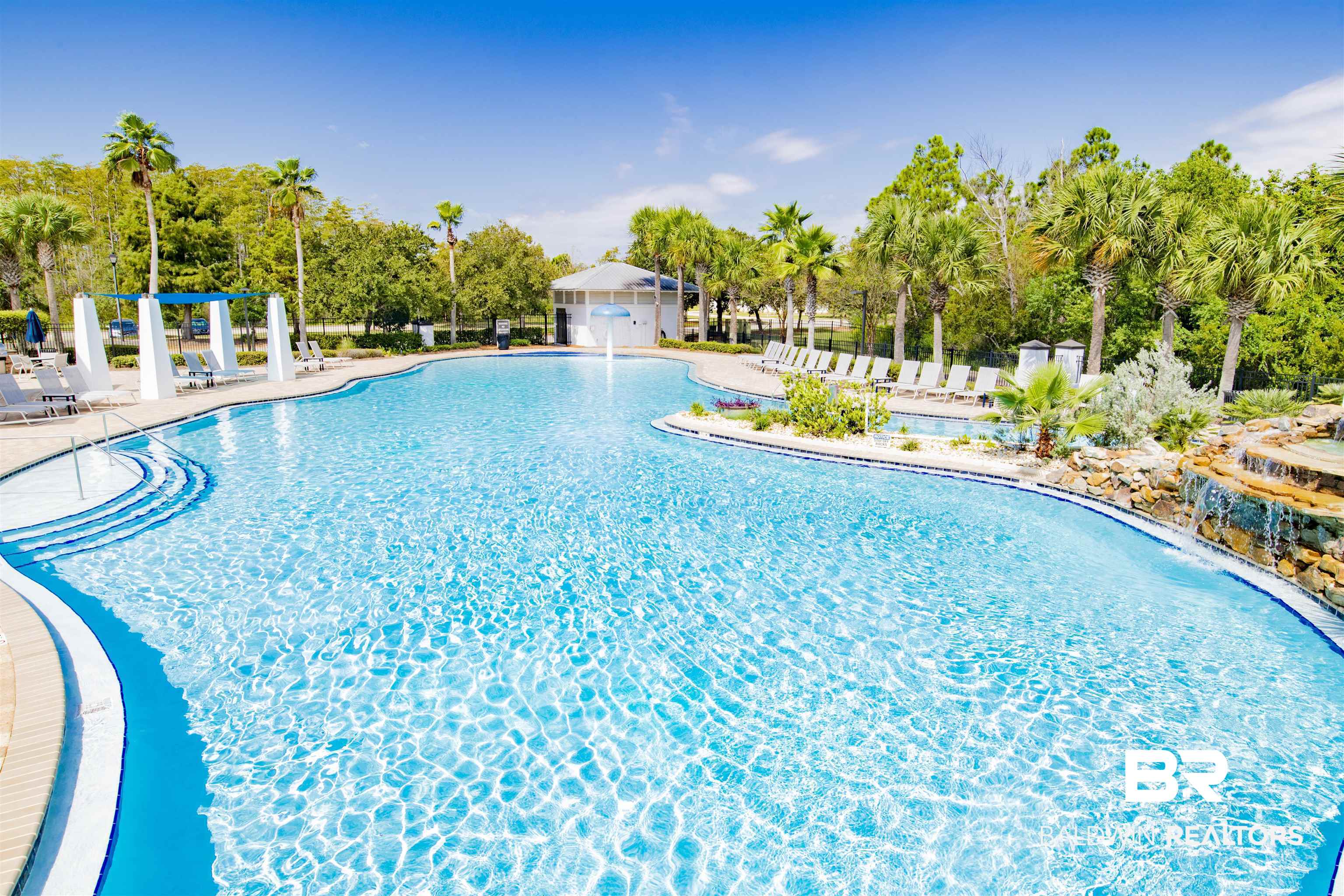 23893 Cypress Crossing Orange Beach, AL 36561 - Photo 13 of 22 Community pool with view of scattered trees and a patio area