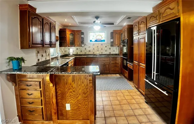 an empty room with wooden floor chandelier fan and windows