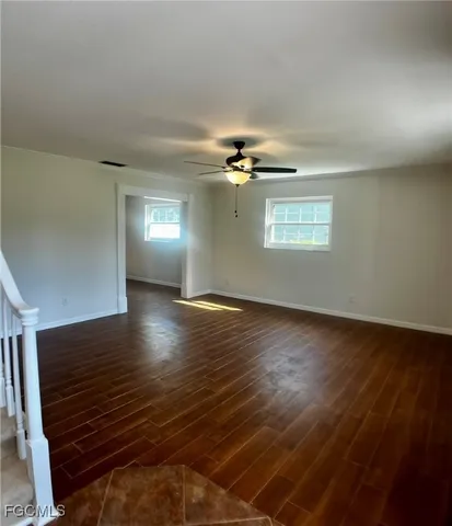 a view of empty room with wooden floor