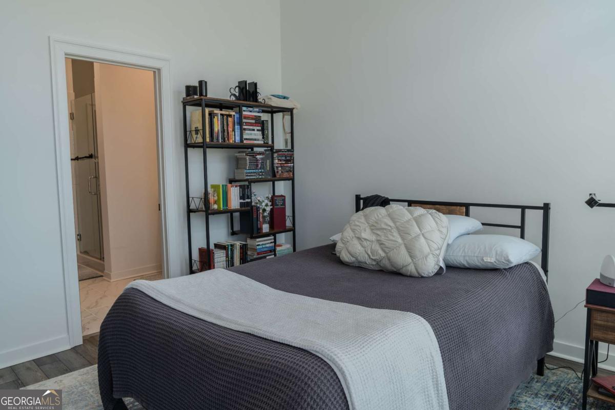 133 Devore Road, Unit 208 Alpharetta, GA 30009 - Photo 11 of 20 a bedroom with a large bed and a book shelf