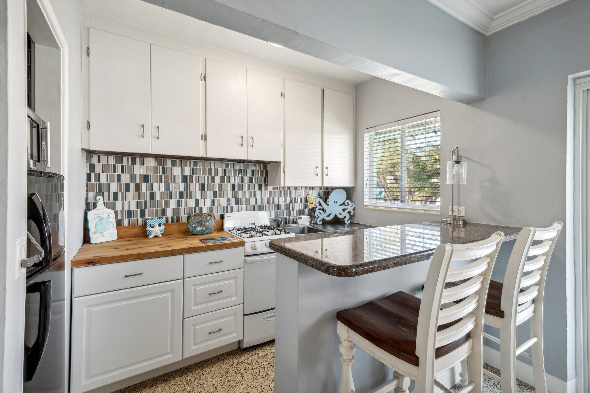 1006 Casuarina Road, Unit 11 Delray Beach, FL 33483 - Photo 9 of 19 a kitchen with granite countertop a sink a stove and cabinets