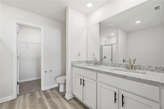a spacious bathroom with a granite countertop sink a toilet and a shower
