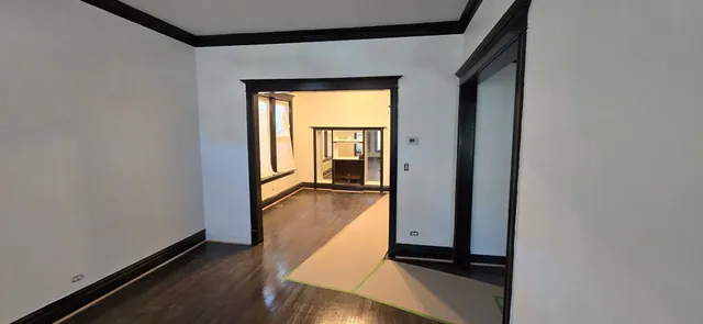 a view of a hallway with wooden floor and a living room