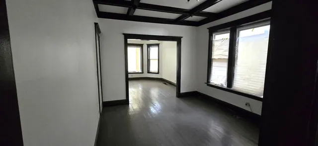 a view of a livingroom with wooden floor and a window