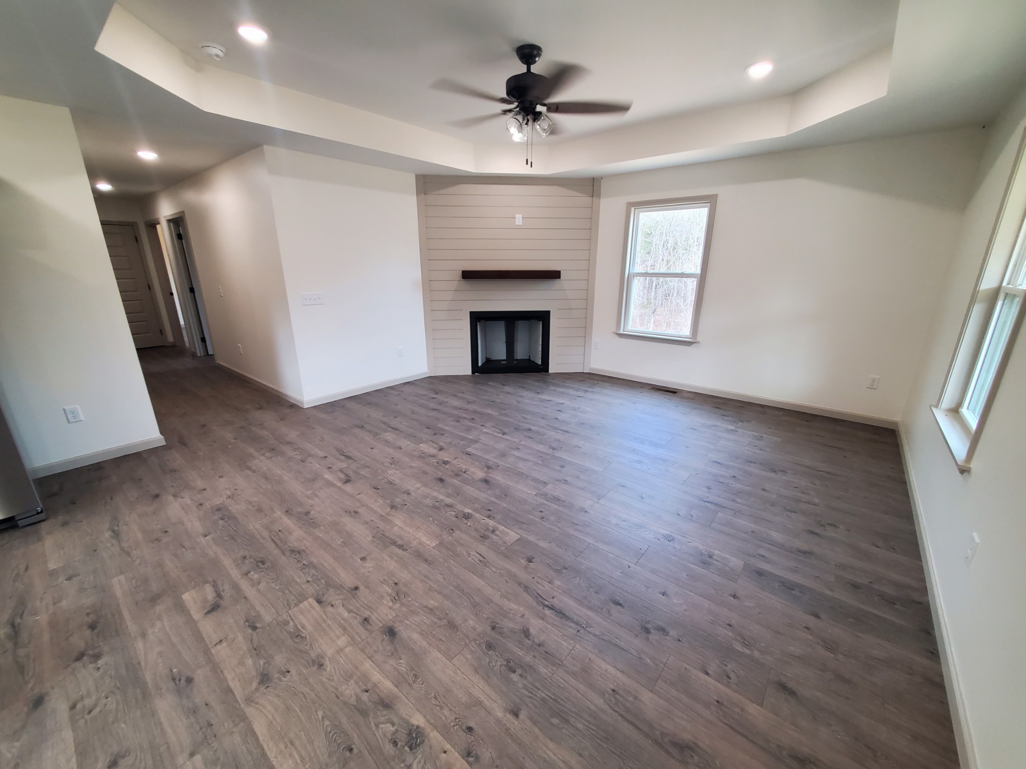 155 Fitzpatrick Road Buffalo Valley, TN 38548 - Photo 6 of 19 an empty room with wooden floor fireplace and windows