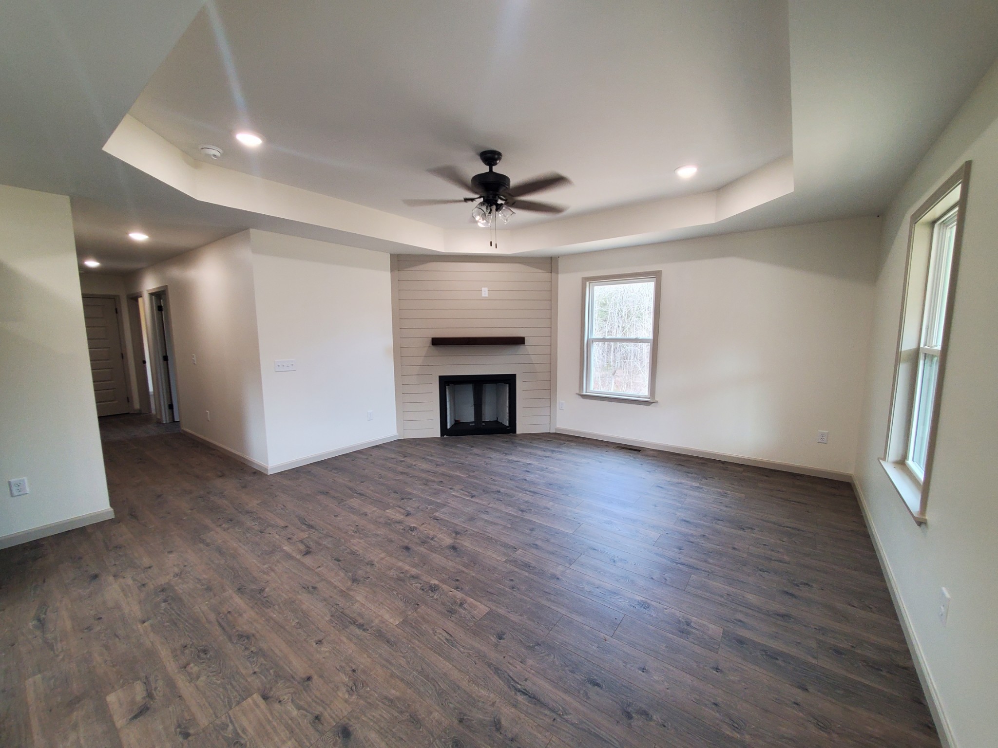 155 Fitzpatrick Road Buffalo Valley, TN 38548 - Photo 7 of 19 an empty room with wooden floor fireplace and windows