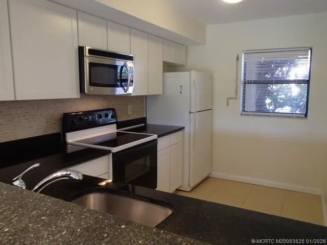 a kitchen that has a sink and a stove top oven