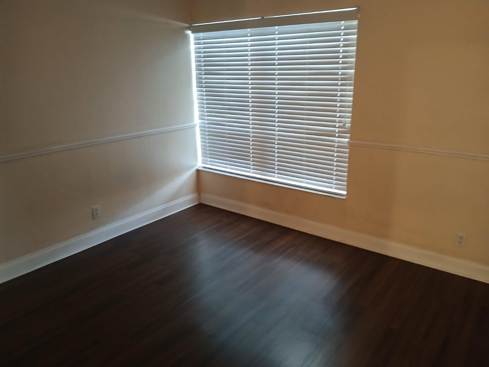 2339 Southwest 15th Street, Unit 19 Deerfield Beach, FL 33442 - Photo 13 of 15 an empty room with wooden floor and a window