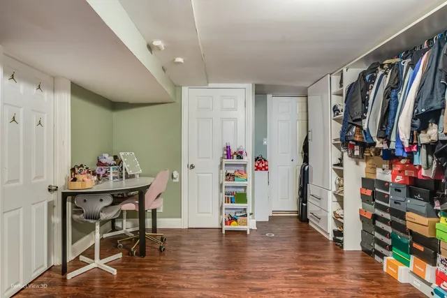a view of a hallway with wooden floor and furniture