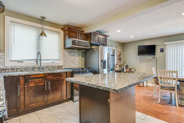 a kitchen with stainless steel appliances granite countertop a sink stove and refrigerator