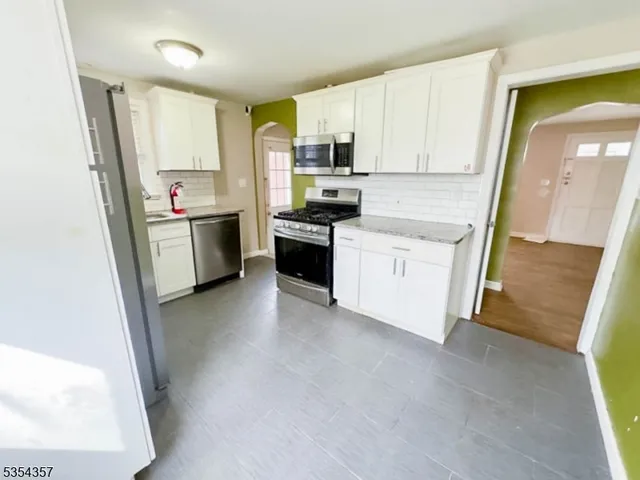 a kitchen with white cabinets and white appliances