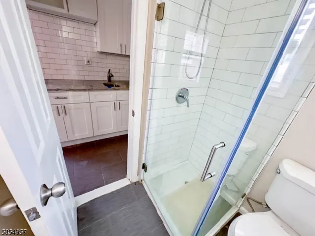 a bathroom with a granite countertop sink toilet and shower
