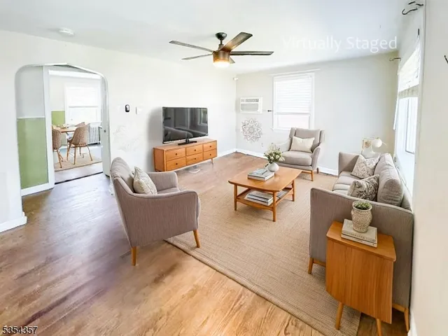 a living room with furniture kitchen view and a flat screen tv