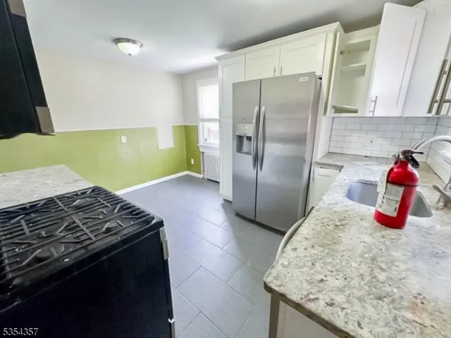 a kitchen with granite countertop a stove and a refrigerator