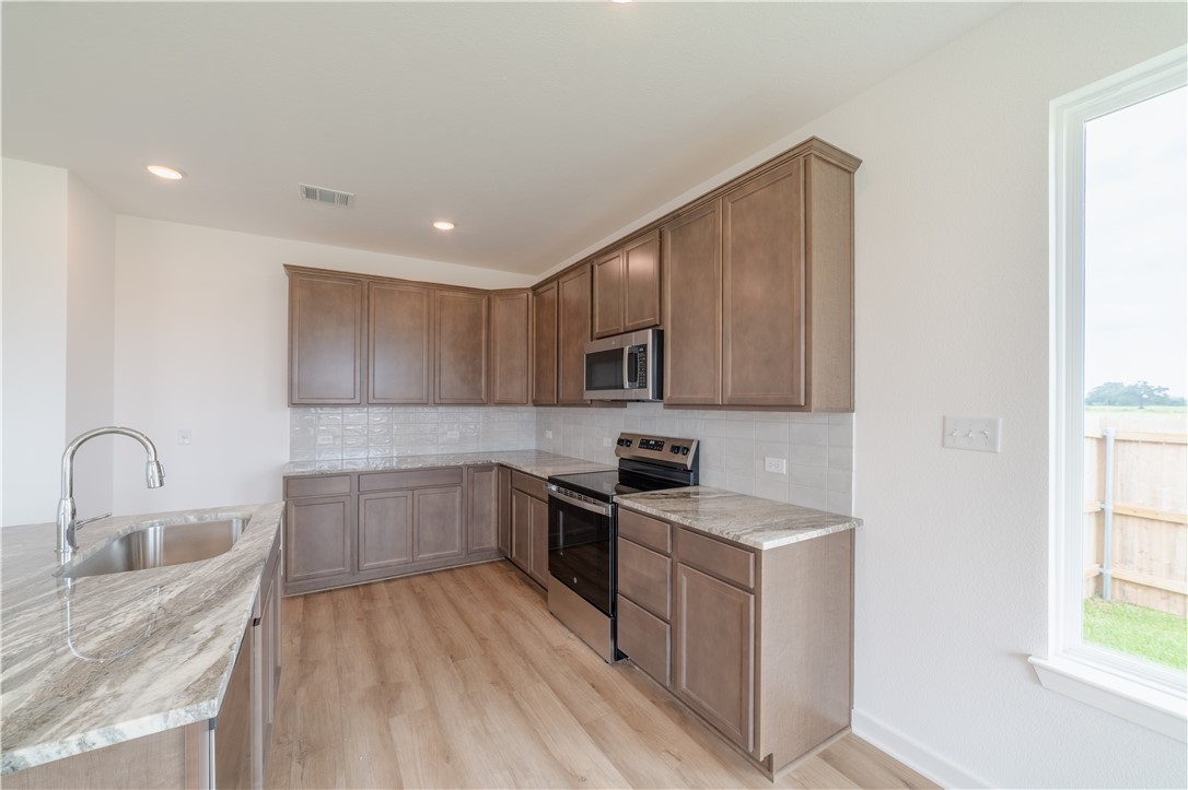 1901 Sebright Drive Bryan, TX 77807 - Photo 4 of 13 a kitchen with stainless steel appliances granite countertop a sink stove and refrigerator