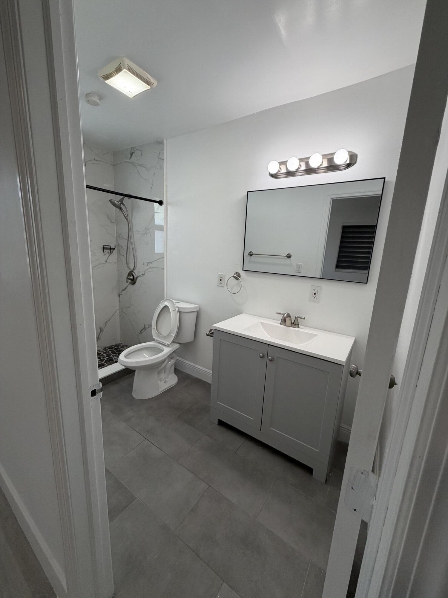7 Sunset Road, Unit 5 Key Largo, FL 33037 - Photo 5 of 7 a bathroom with a toilet sink and mirror