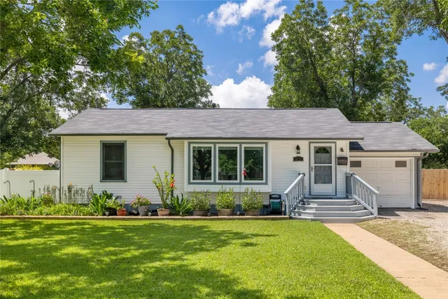 a front view of a house with a garden and plants