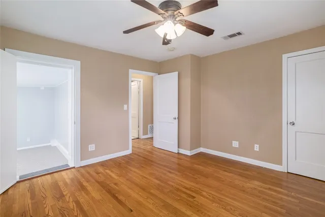 a view of a room with wooden floor and ceiling fan