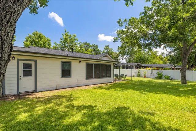 a view of a backyard with table and chairs and wooden fence