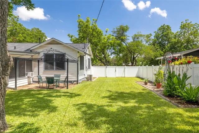 a view of a house with backyard and sitting area