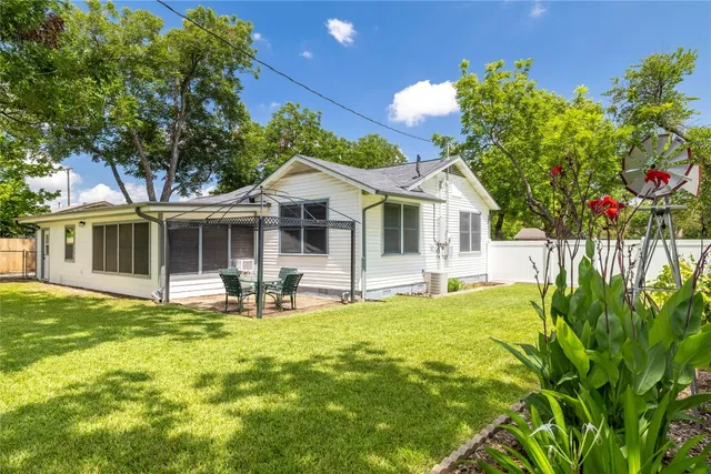 a view of house with backyard and sitting area