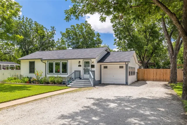 a view of a house with a yard and large tree